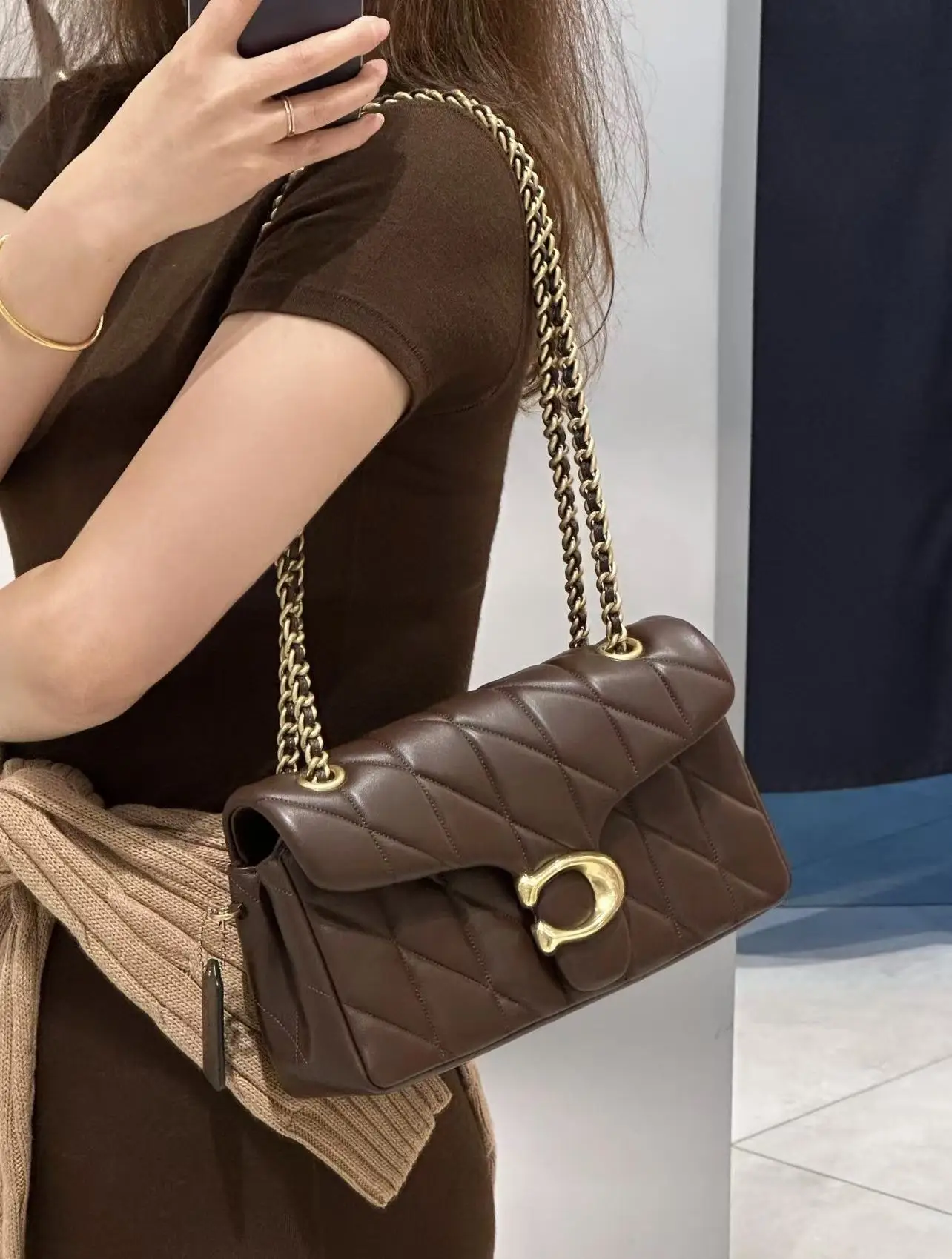 Bruine Nora Gewatteerde Crossbody gedragen met goudkleurige ketting