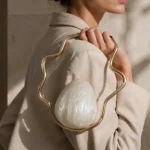 Pearl Frame Clutch met parelmoerachtige schelp gedragen in de hand